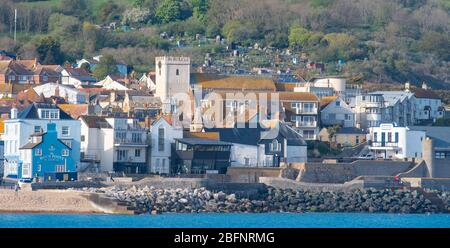 Lyme Regis, Dorset, Regno Unito. 19 Apr 2020. Tempo in Gran Bretagna: La graziosa località costiera è bagnata dal caldo sole del tardo pomeriggio. La città è molto più tranquilla del normale, come la gente osserva le distanze sociali durante il blocco coronavirus. Credit: Celia McMahon/Alamy Live News Foto Stock