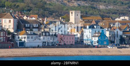 Lyme Regis, Dorset, Regno Unito. 19 Apr 2020. Tempo in Gran Bretagna: La graziosa località costiera è bagnata dal caldo sole del tardo pomeriggio. La città è molto più tranquilla del normale, come la gente osserva le distanze sociali durante il blocco coronavirus. Credit: Celia McMahon/Alamy Live News Foto Stock