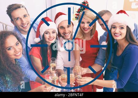 Concetto di tempo. Giovani con bicchieri di champagne durante la festa di Natale in occasione di un party aziendale Foto Stock