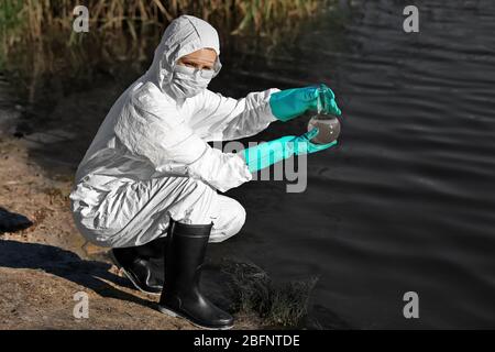 Concetto di perdite di olio. Donna con fiasca per esperienza a terra Foto Stock