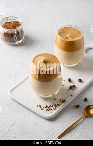 Due bicchieri di caffè Dalgona su sfondo bianco chiaro. Inquadratura verticale. Primo piano. Foto Stock