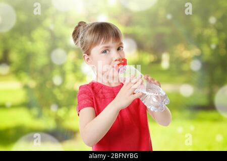 Bambina con bottiglia di acqua pulita su sfondo sfocato Foto Stock