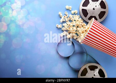 Composizione a posa piatta con popcorn, filmstrip e spazio per testo su sfondo a colori. Serata al cinema Foto Stock