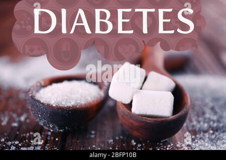 Diabete di parola e cucchiai con zucchero su tavola di legno Foto Stock