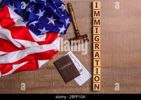 Cubi con l'IMMIGRAZIONE di parola, gavel del giudice e bandiera americana sul tavolo Foto Stock