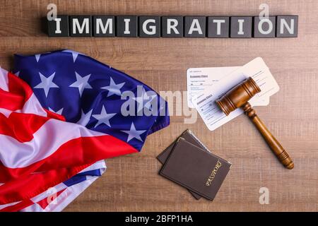 Cubi con l'IMMIGRAZIONE di parola, gavel del giudice e bandiera americana sul tavolo Foto Stock