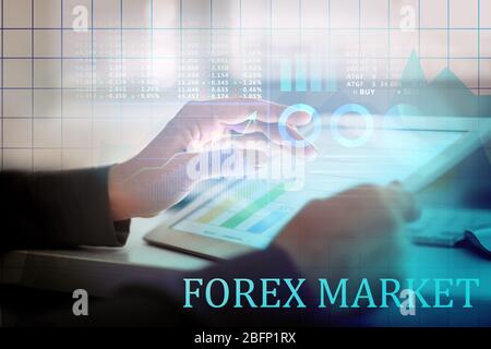 Doppia esposizione di grafici e commerciante finanziario che lavora con il tablet al tavolo in ufficio. Concetto Forex Foto Stock