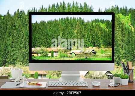 Immagine concettuale di uno spazio di lavoro e desktop con piccolo villaggio in montagna Foto Stock