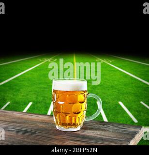 Bicchiere di birra sullo sfondo dello stadio di calcio Foto Stock