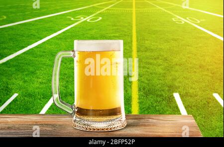 Bicchiere di birra sullo sfondo dello stadio di calcio Foto Stock