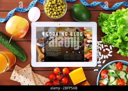 Verdure fresche e tavoletta su tavolo di legno, vista dall'alto. Concetto di blog di cucina Foto Stock