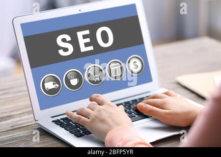 Concetto di tecnologia SEO. Donna che usa un notebook in ufficio. Foto Stock