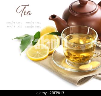 Tazza di tè in vetro con teiera e fette di limone su sfondo bianco. Spazio per il testo. Foto Stock