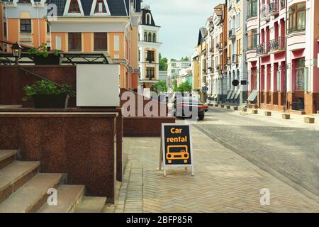 Affissioni con testo noleggio auto in città strada. Foto Stock