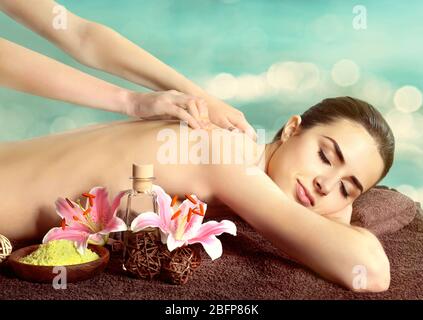 Concetto di Spa. Bella donna che ha massaggio a tavola. Sfondo blu sfocato. Foto Stock