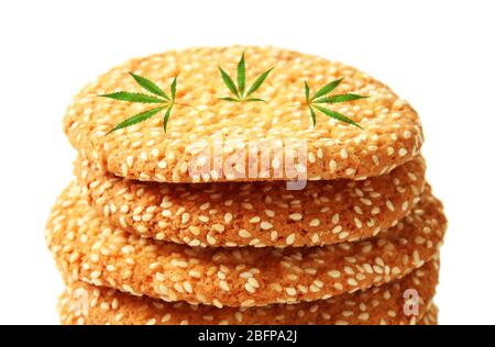 Gustosi biscotti con foglie di marijuana su sfondo bianco, primo piano Foto Stock