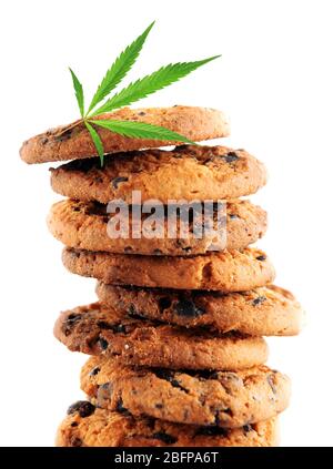 Gustosi biscotti con foglie di marijuana su sfondo bianco, primo piano Foto Stock