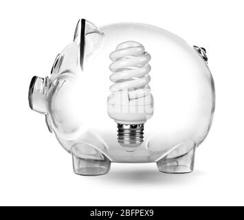 Piggy bank con lampadina su sfondo bianco. Aumento dei costi dell'elettricità Foto Stock