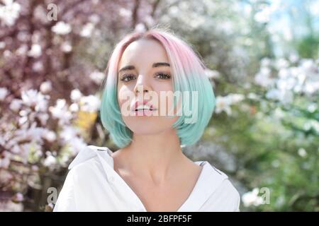 Idee alla moda. Giovane donna con accento di colore menta in acconciatura all'aperto Foto Stock