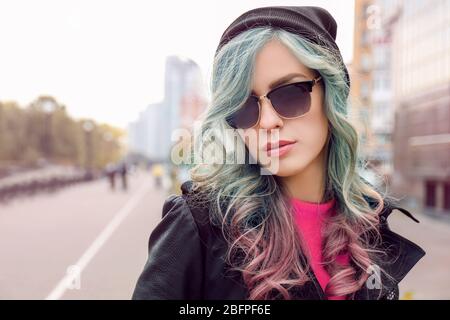 Donna trendy ideas.Young con accento di colore menta in acconciatura all'aperto Foto Stock