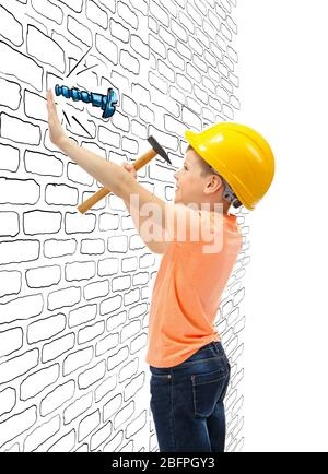 Bambino martellando chiodo vite trafilato in parete su sfondo bianco Foto Stock