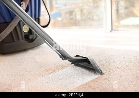 Concetto di servizio di pulizia. Pulitore per vapori di vapore per rimuovere lo sporco dal tappeto in piano Foto Stock