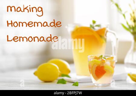 Bicchiere di bevanda rinfrescante con limone e pompelmo a tavola. Testo CHE FA LA LIMONATA FATTA IN CASA sullo sfondo Foto Stock