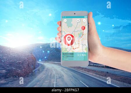 Concetto di app di viaggio. Donna che utilizza l'applicazione mappa nello smartphone per pianificare il percorso e la strada sullo sfondo Foto Stock