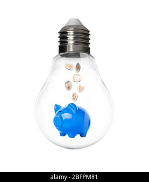 Piggy bank con monete all'interno della lampadina su sfondo bianco. Aumento dei costi dell'elettricità Foto Stock