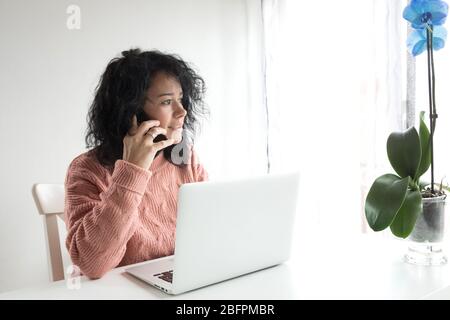una donna intraprendente lavora da casa con il computer Foto Stock