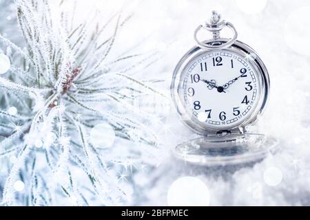 Conto alla rovescia per le celebrazioni natalizie. Orologio tascabile e ramo conifere, closeup Foto Stock