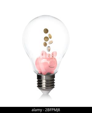 Piggy bank con monete all'interno della lampadina su sfondo bianco. Aumento dei costi dell'elettricità Foto Stock