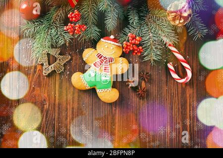 Composizione con gustosi biscotti di pan di zenzero e luci di Natale su sfondo di legno Foto Stock