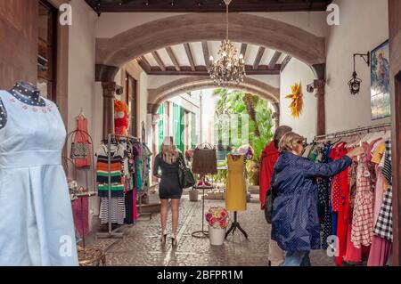 Sóller, Isole Baleari/Spagna; 03/27/2015: Negozio di abbigliamento nella città di Sóller. Architettura tradizionale e clienti Foto Stock