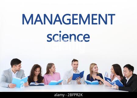 Concetto di scienza di gestione. Giovani che leggono libri a tavola Foto Stock