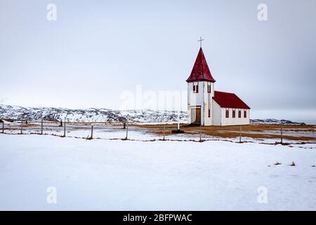 La chiesa di Hellnakirkja con il tetto rosso a Hellnar nella penisola di Snaefellsnes sulla neve in una giornata invernale, l'Islanda Foto Stock