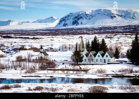 Vista dall'alto del famoso sito turistico del Parco Nazionale di Thingvellir - Pingvellir - chiesa e case innevate in inverno Foto Stock
