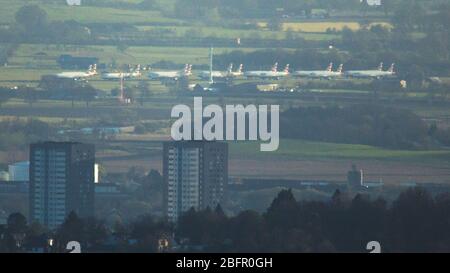 Lennoxtown, Regno Unito. 19 Apr 2020. Nella foto: Teleobiettivo aereo dell'aeroporto internazionale di Glasgow con 13 aerei British Airways Airbus a terra parcheggiati sul asfalto (a destra della pista principale) a causa del blocco del Regno Unito e Coronavirus (COVID-19) Pandemic. Dal blocco la maggior parte delle compagnie aeree hanno dovuto licenziare il personale con la maggior parte di necessità di assistenza finanziaria pubblica o il rischio collasso. Ad oggi nel Regno Unito i casi confermati di persone infette sono 120,067 con 16,060 morti. Credit: Colin Fisher/Alamy Live News Foto Stock