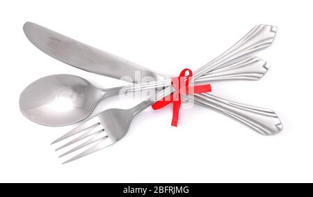Forchetta e cucchiaio in argento, coltello legato con un nastro rosso isolato su bianco Foto Stock