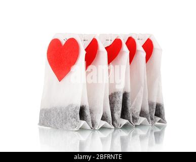 Bustine da tè con etichette bianche a forma di cuore isolate su bianco Foto Stock