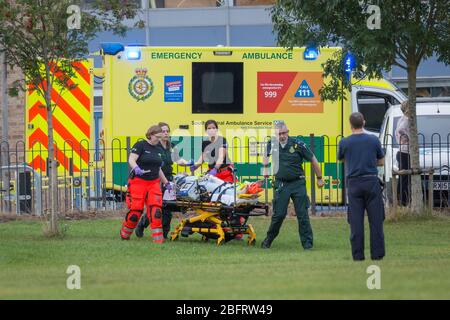 Team di emergenza NHS che consegna il paziente a Hampshire e all'isola di Wight Air Ambulance - Airbus H135 G-HIOW a Basingstoke, Regno Unito Foto Stock