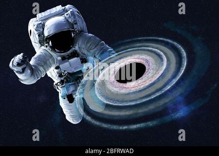 Astronauta vicino colorato buco nero in qualche luogo nello spazio. Sfondo spaziale drammatico. Fantascienza. Elementi di questa immagine sono stati forniti dalla NASA Foto Stock