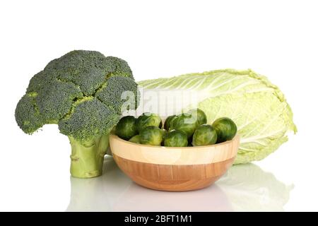 Cavoli di Bruxelles in ciotola di legno con broccoli e cavolo isolati su bianco Foto Stock