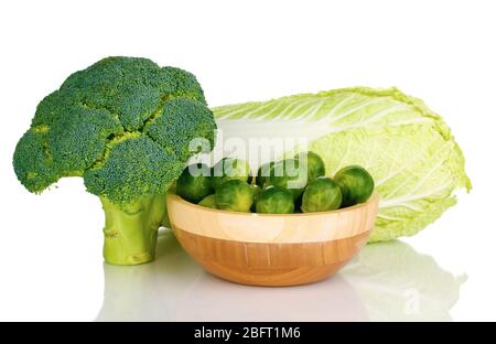 Cavoli di Bruxelles in ciotola di legno con broccoli e cavolo isolati su bianco Foto Stock