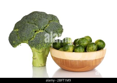 Cavoli di Bruxelles in ciotola di legno e broccoli isolati su bianco Foto Stock