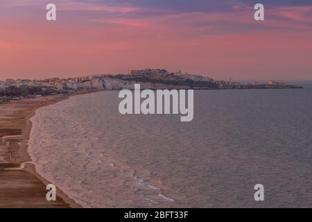 Lunga spiaggia di sabbia di Castello e skyline di Vieste sulla penisola del Gargano al tramonto. Italia Foto Stock