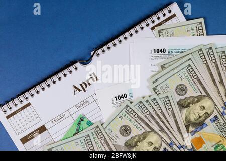 American Tax 1040 modulo e assegno di rimborso e dollari USA banconote da cento dollari pagare l'imposta Foto Stock