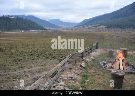 Un bagno tradizionale in pietra calda completo di un fuoco da campeggio e vista della valle di Phobjika, Bhutan. Foto Stock