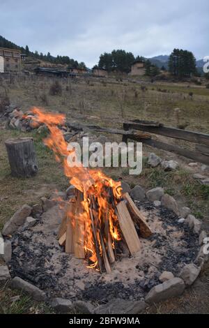 Un bagno tradizionale in pietra calda completo di un fuoco da campeggio e vista della valle di Phobjika, Bhutan. Foto Stock