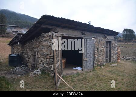 Un bagno tradizionale in pietra calda completo di un fuoco da campeggio e vista della valle di Phobjika, Bhutan. Foto Stock